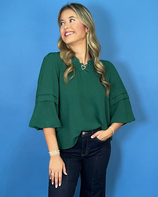 Emerald green blouse with a ruffled V-neckline, three-quarter bell sleeves, and relaxed fit.