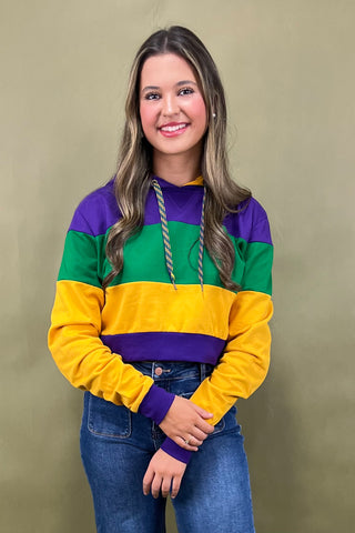 Woman wearing a colorful striped sweater against a beige background