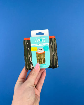 Shop the Swig Woodland Camo Coolies for cans and slim cans. Insulated, reusable sleeves with card pocket, hand strap, and rugged camo style.