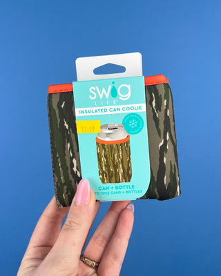 Shop the Swig Woodland Camo Coolies for cans and slim cans. Insulated, reusable sleeves with card pocket, hand strap, and rugged camo style.