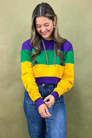 Woman wearing a colorful striped sweater against a plain background