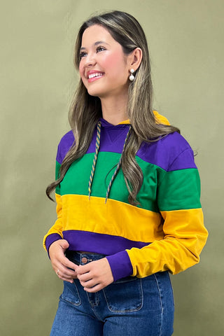 Woman wearing a colorful striped sweater against a green background