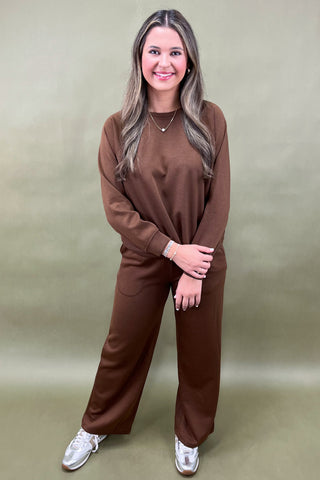 Woman wearing a brown outfit against a beige background