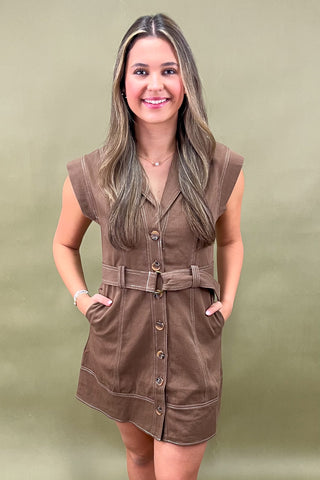 Brown belted button-front mini dress with structured seams and capped sleeves, styled for a chic and casual fall look.
