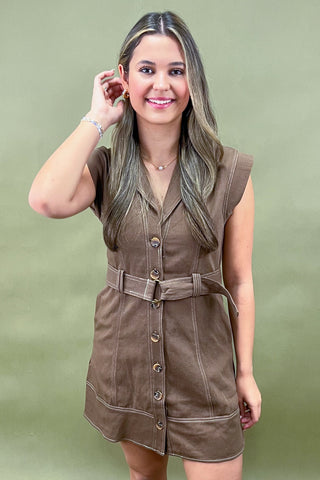Brown belted button-front mini dress with structured seams and capped sleeves, styled for a chic and casual fall look.