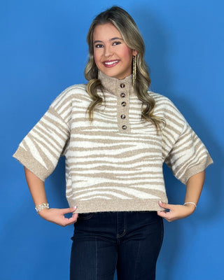 Taupe and ivory zebra stripe sweater with a button mock neck, short sleeves, and relaxed fit.