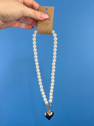 Shop the Heart Charm Pearl Necklace featuring classic faux pearls, a gold heart charm, and a stylish toggle clasp for timeless elegance.