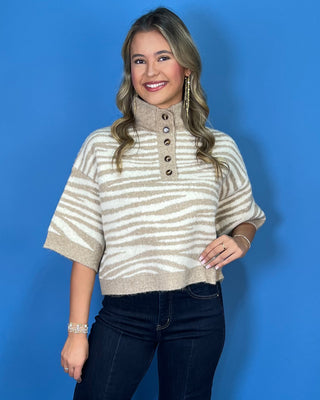 Taupe and ivory zebra stripe sweater with a button mock neck, short sleeves, and relaxed fit.