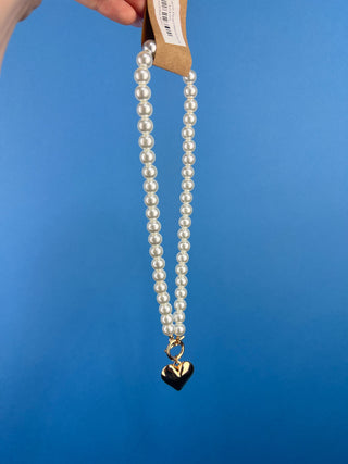 Shop the Heart Charm Pearl Necklace featuring classic faux pearls, a gold heart charm, and a stylish toggle clasp for timeless elegance.