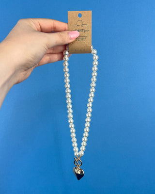 Shop the Heart Charm Pearl Necklace featuring classic faux pearls, a gold heart charm, and a stylish toggle clasp for timeless elegance.