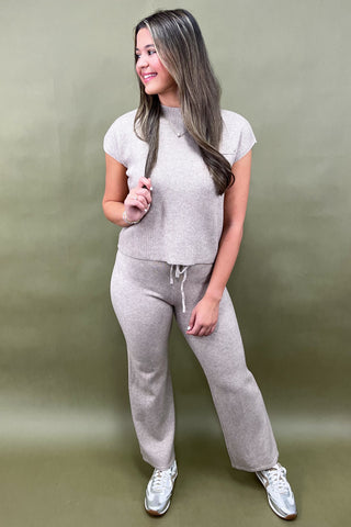 Woman wearing a gray outfit against a green background
