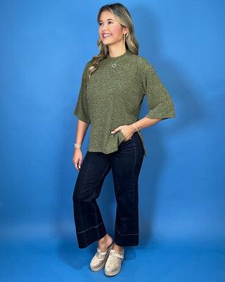 Olive green textured knit top with a round neckline, elbow-length sleeves, and relaxed fit.