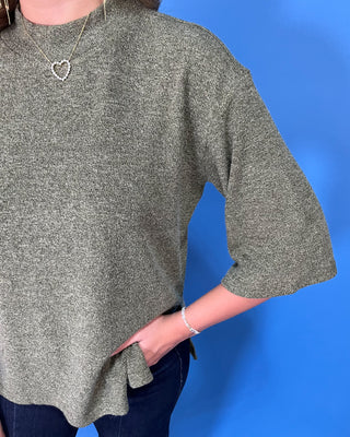 Olive green textured knit top with a round neckline, elbow-length sleeves, and relaxed fit.