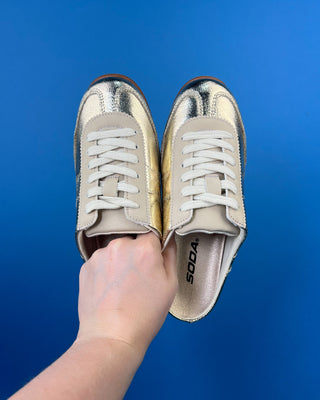 Shop the Stella Metallic Gold Slip On Sneaker featuring a metallic faux leather finish, cushioned comfort, and an easy slip-on design for everyday style.