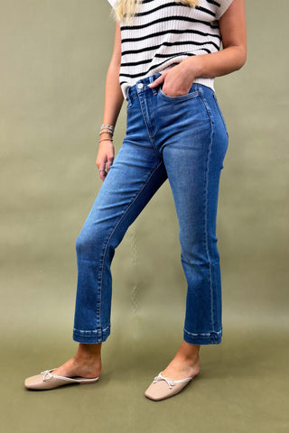 Beige quilted slide sandals on a blue denim background