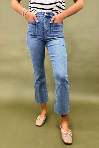 Person wearing blue jeans and a striped top on a green background