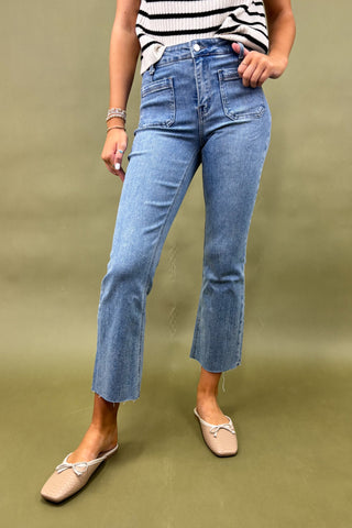 Person wearing blue jeans and a striped top on a green background