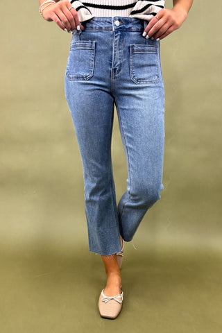 Person wearing blue jeans and a striped shirt on a green background
