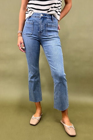 Person wearing blue jeans and a striped top on a green background