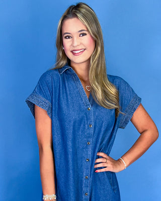 Woman wearing a blue denim dress against a blue background