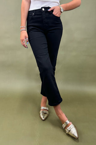Person wearing black pants and gold shoes on a green background