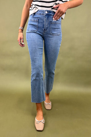Person wearing blue jeans and a striped shirt on a green background