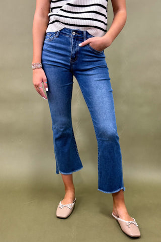 Person wearing blue jeans and a striped top on a plain background
