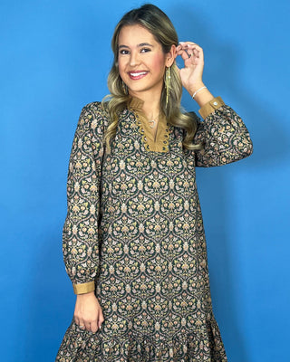 Black floral midi dress with long sleeves, tiered skirt, and contrasting camel ruffle neckline and cuffs.