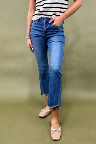 Person wearing blue jeans and a striped shirt on a green background