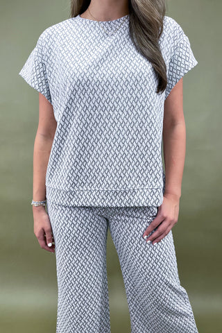 Person wearing a patterned outfit with a plain background