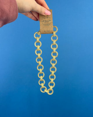 Shop the Gold Link Necklace featuring oversized textured gold links and a stylish toggle clasp for a timeless statement accessory.