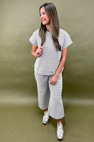 Woman wearing a matching patterned outfit on a green background