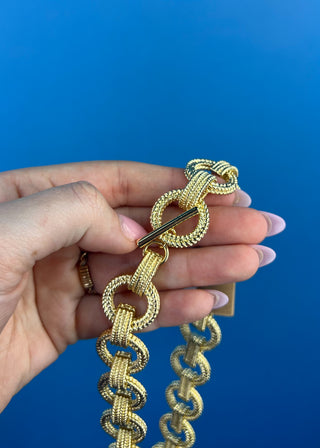 Shop the Gold Link Necklace featuring oversized textured gold links and a stylish toggle clasp for a timeless statement accessory.