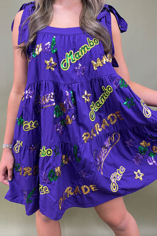 Purple dress with 'Mambo Parade' text and designs on a plain background