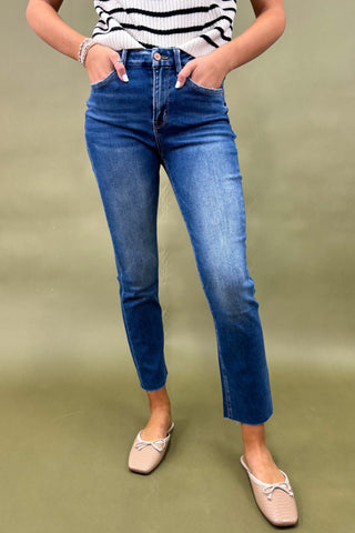 Person wearing blue jeans and a striped top on a green background