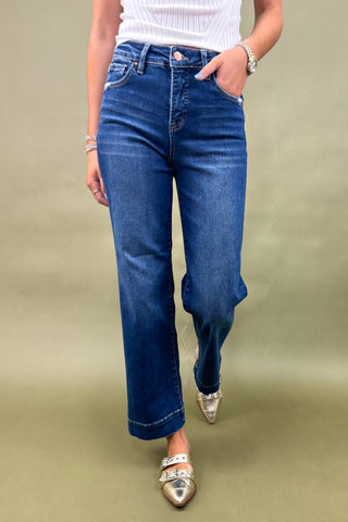 Person wearing blue jeans on a beige background