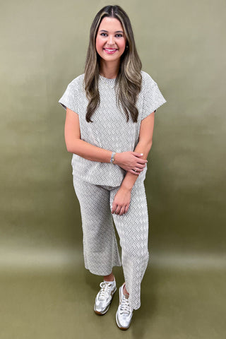 Woman wearing a patterned outfit against a plain background