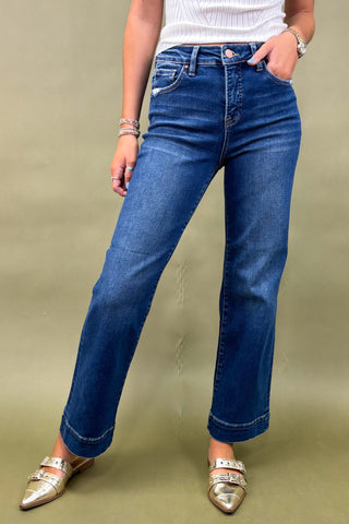 Person wearing blue jeans on a beige background