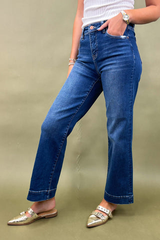 Person wearing blue jeans on a beige background
