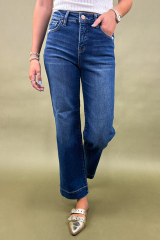 Person wearing blue jeans on a beige background