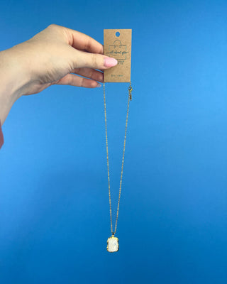 Shop the Opaque Stone Necklace featuring a marbled ivory stone pendant, textured gold frame, and delicate chain for timeless everyday style.