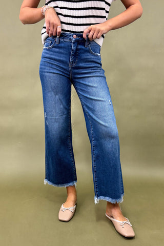 Person wearing blue jeans and a striped top on a green background