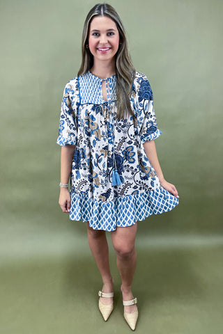 Woman wearing a blue and white patterned dress on a green background