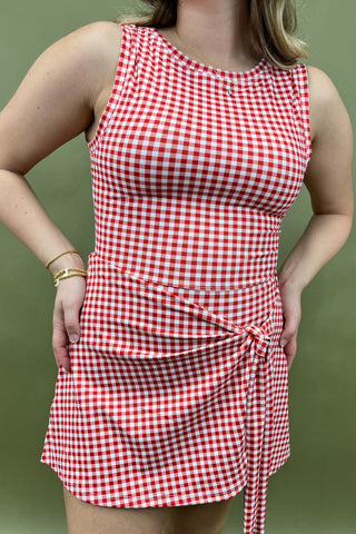 Red and white checkered dress worn by a person on a green background