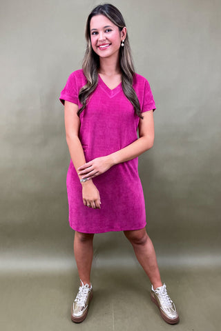 Woman wearing a pink dress against a plain background