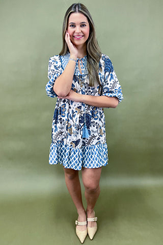 Woman wearing a patterned dress against a green background