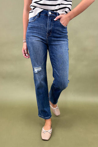 Person wearing blue jeans and a striped shirt on a green background