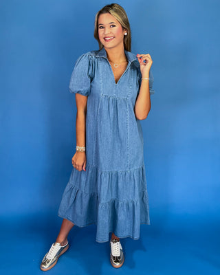 Woman wearing a blue denim dress against a blue background