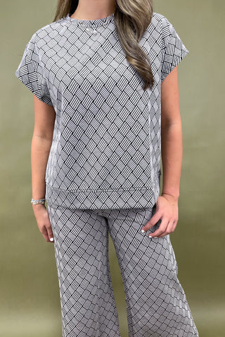 Person wearing a patterned outfit with a plain background