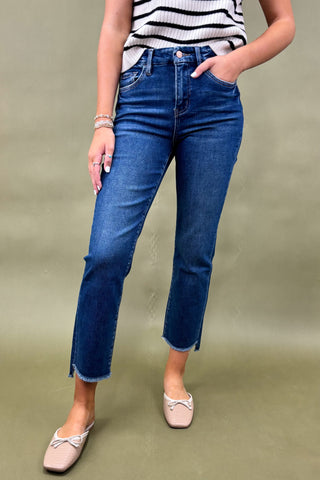 Person wearing blue jeans and a striped top on a green background